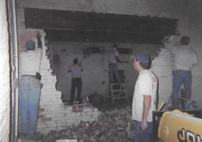 The brothers knocking an opening through a brick wall by hand